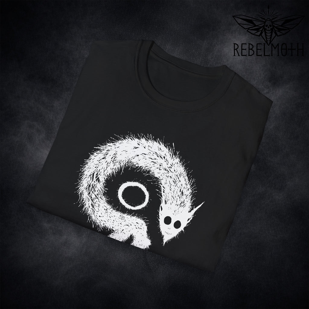 Close-up of demon creature graphic print with oversized eye and spiked silhouette on black t-shirt