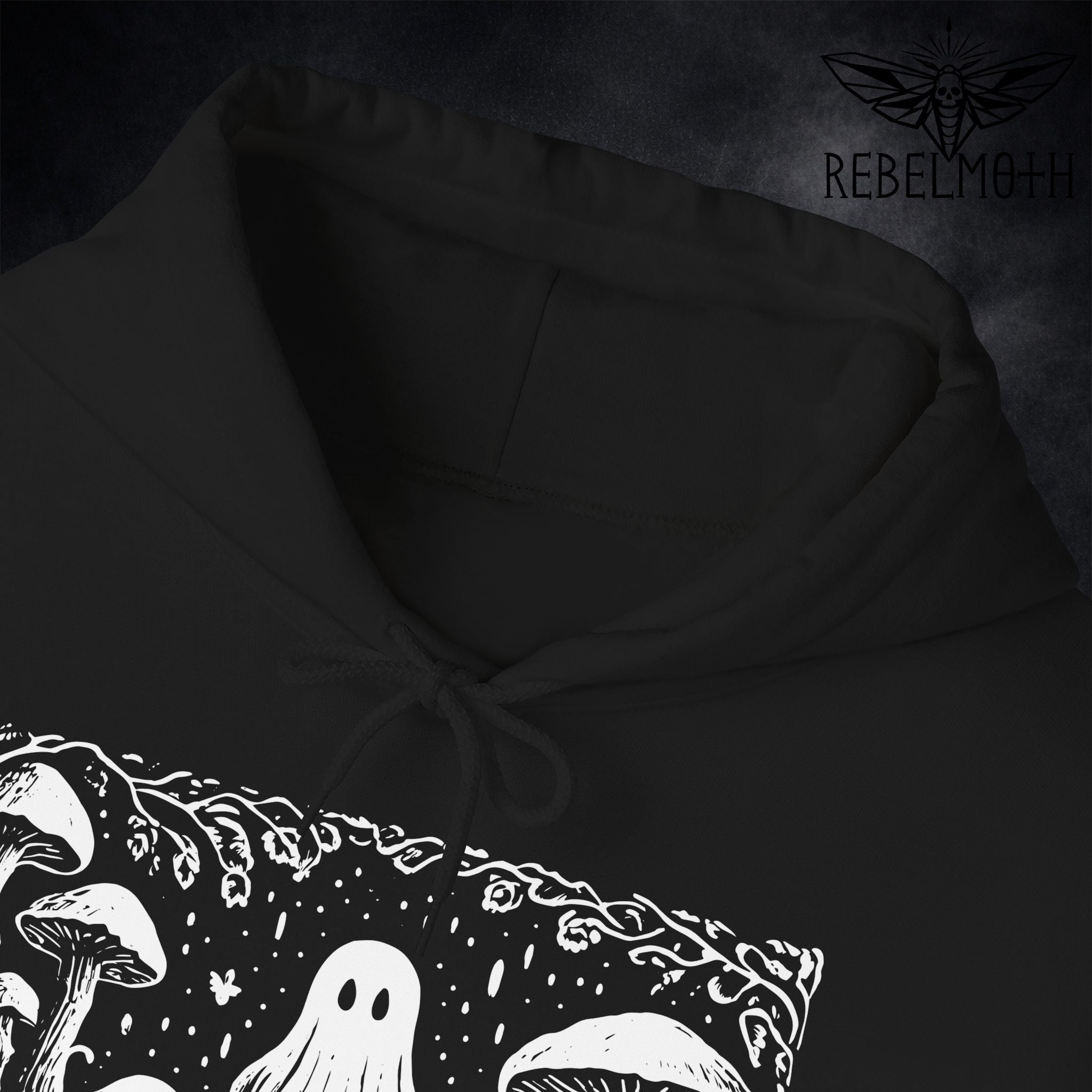 Close-up of ghost and mushroom forest linocut artwork showing textured linework on hoodie