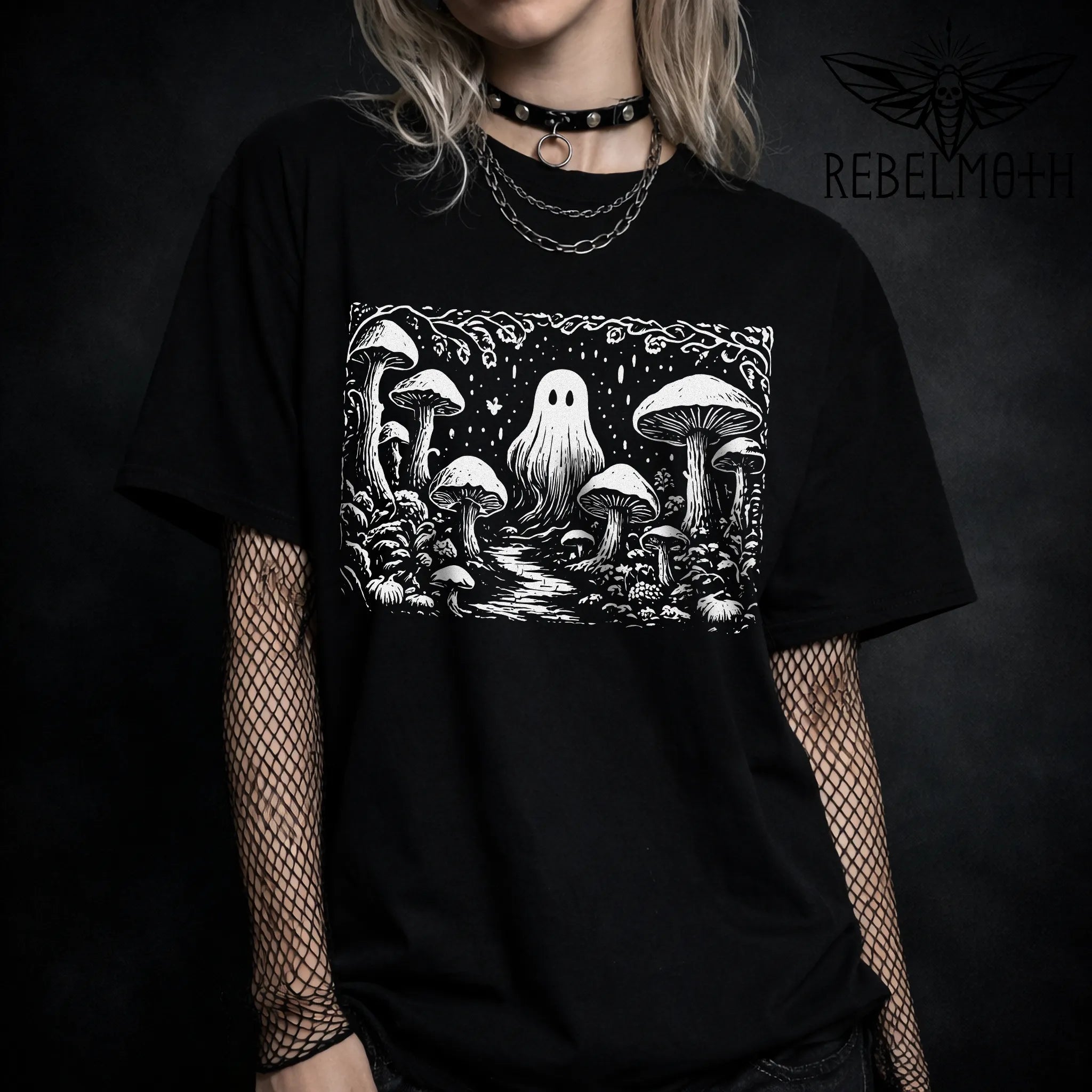 Black t-shirt with a ghost and mushroom design, worn by a person on a dark background.