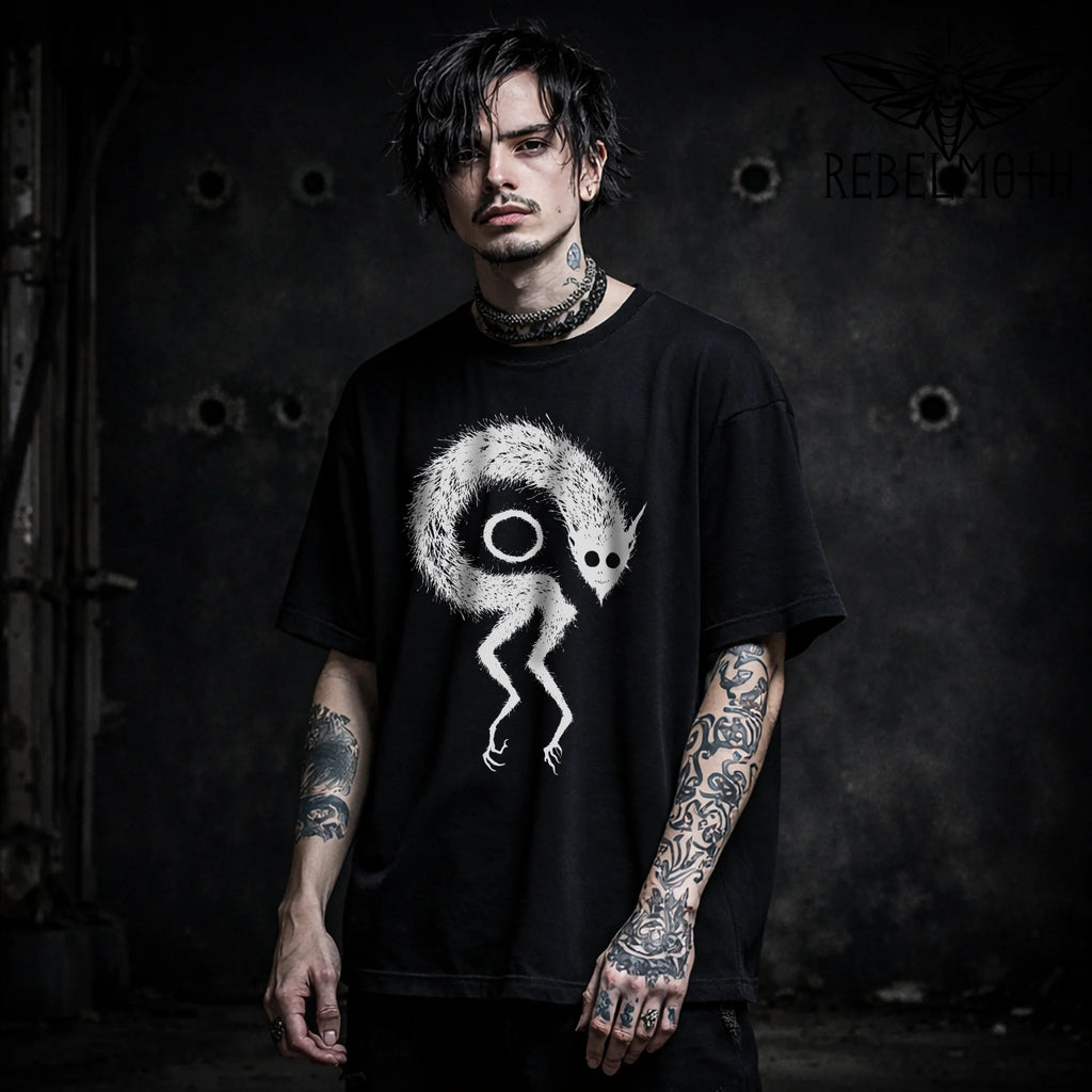Model wearing a weird demon monster goth t-shirt with occult graphic, front view