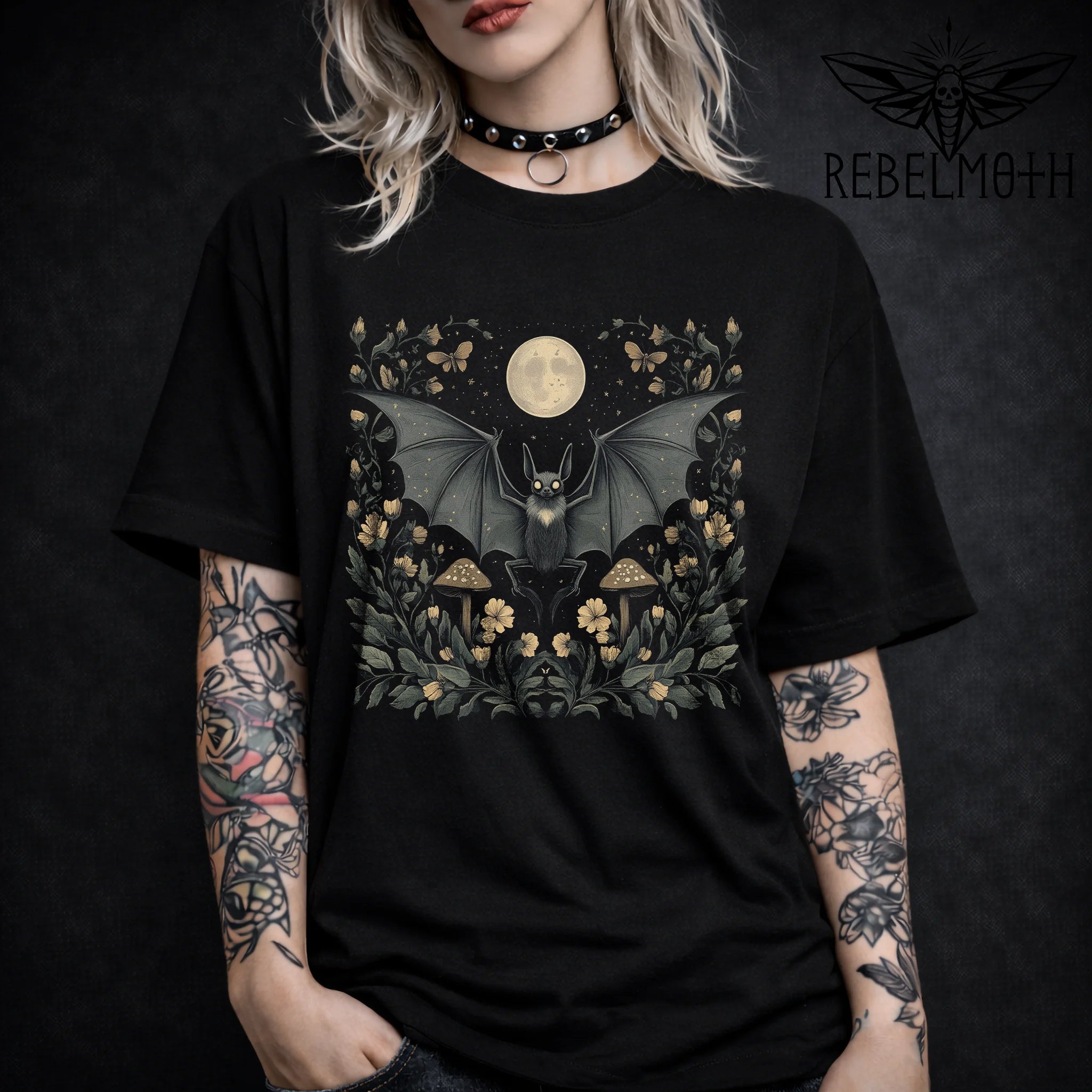 Pastel goth bat t-shirt with a full moon, flowers and mushrooms in a soft dark cottagecore style. Witchy floral graphic tee for alt outfits.